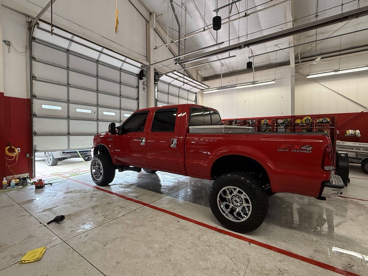 Owner of Clean Company Detailing working on a truck inside a fire station bay