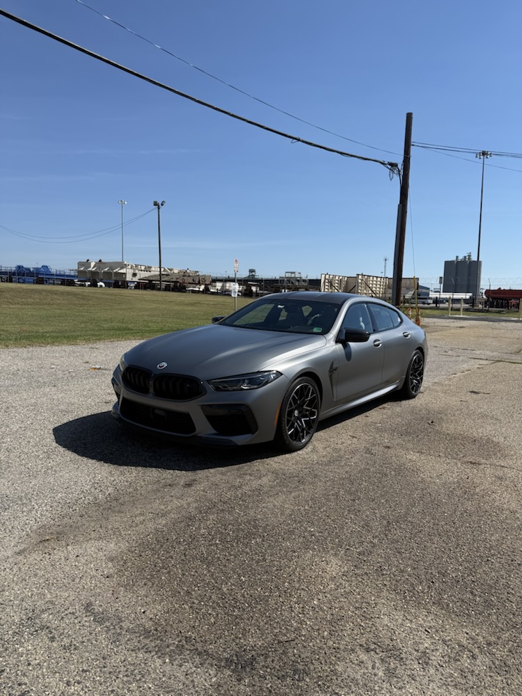 BMW M8 Gran Coupe parked on gravel after a detail